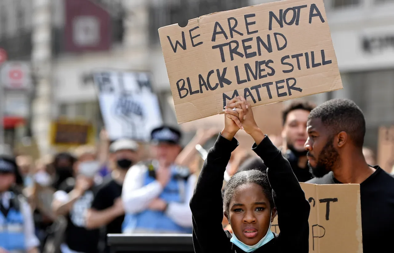 Girl holds sign in london uk blm