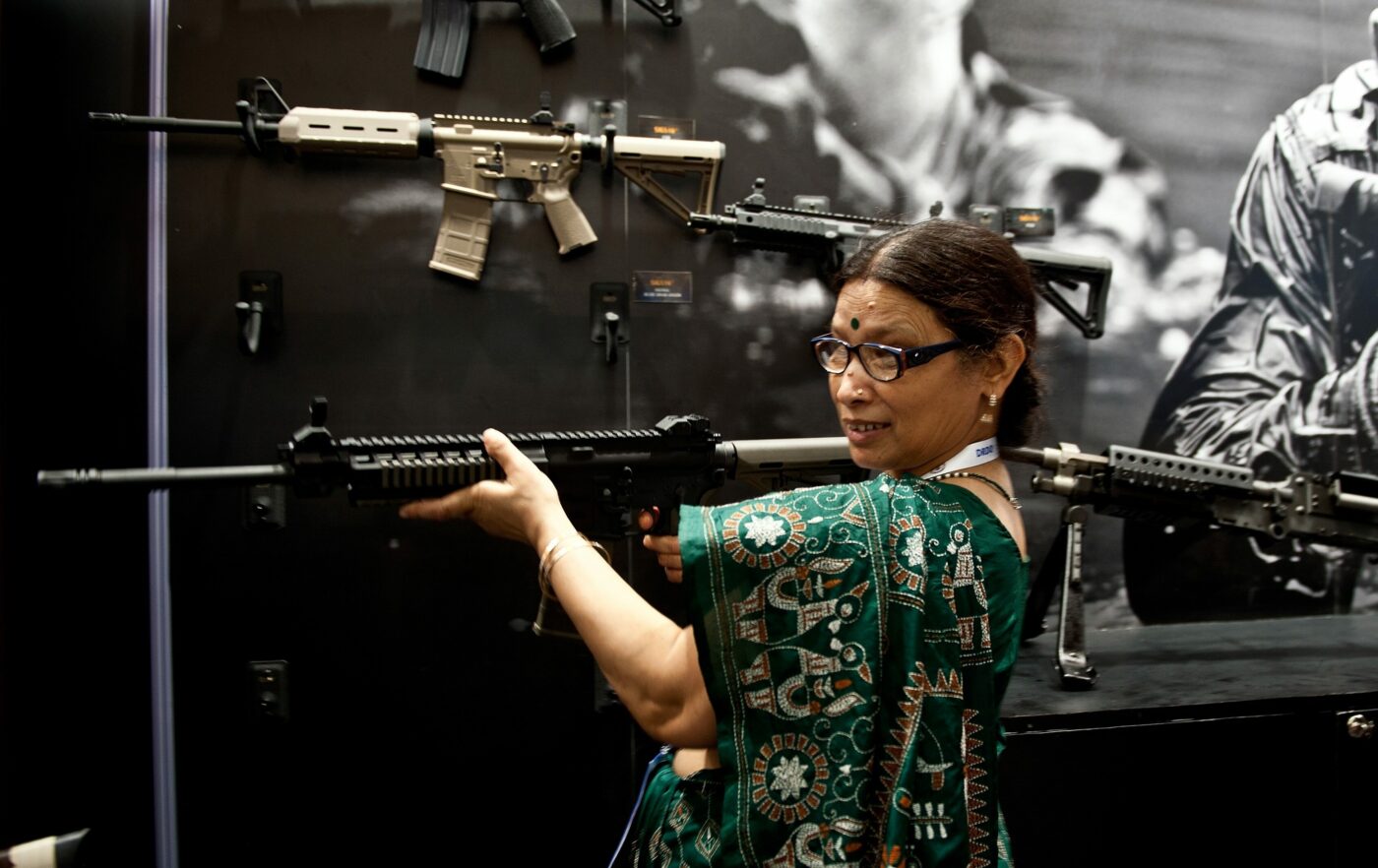 An Indian woman tries out an assault wea